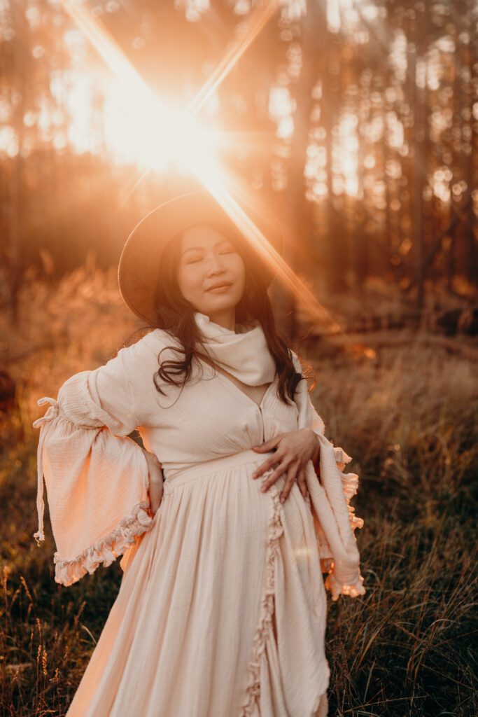 Schwangere Frau im Sonnenuntergang