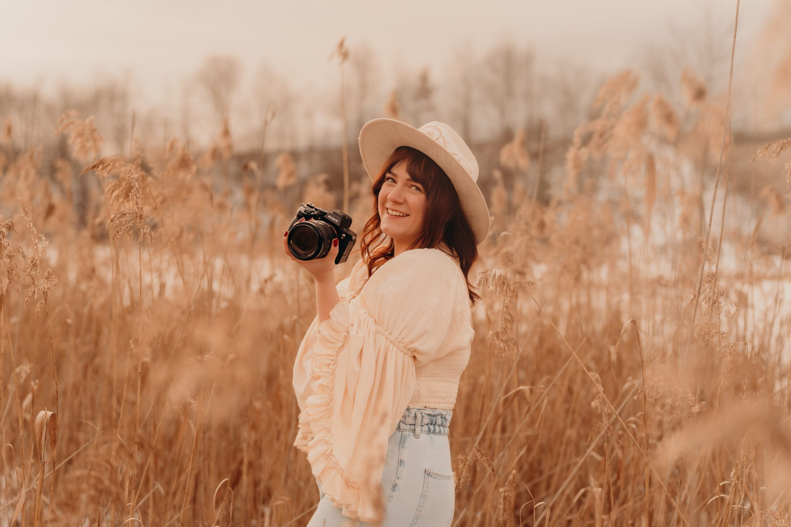 Frau mit Hut und Kamera