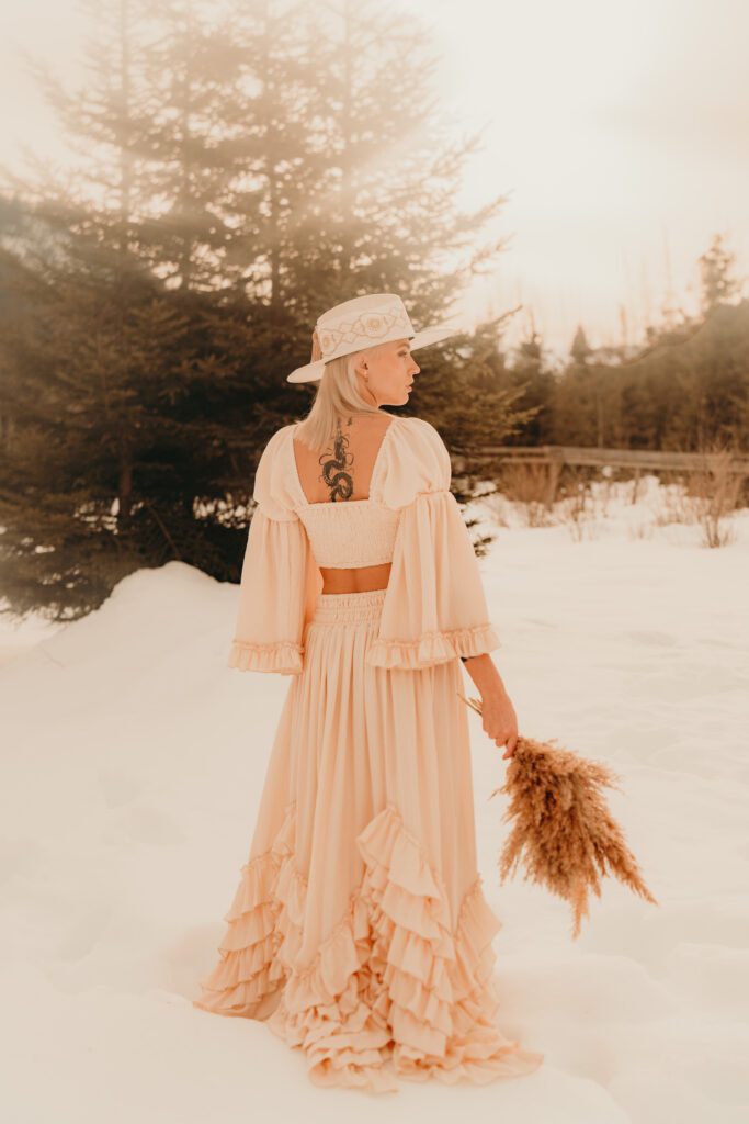 Frau mit Hut, Bohokleid und Blumenstrauß
